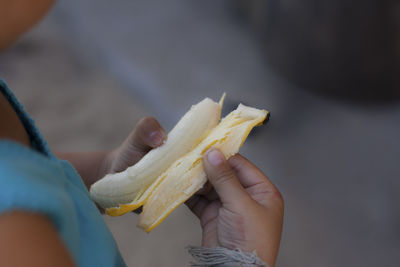 Children's hands are peeling bananas.