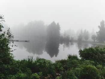 Scenic view of lake against sky during foggy weather