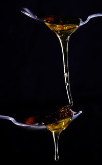 Close-up of wineglass on glass against black background