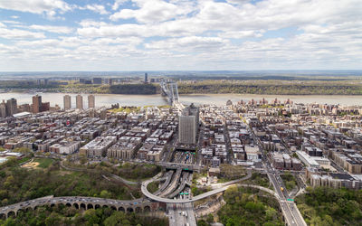 High angle view of cityscape by sea against sky