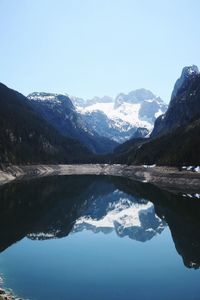 Scenic view of lake and mountains against clear blue sky