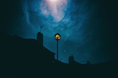 Low angle view of street light against building at night