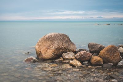 Rocks in sea against sky