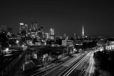 High angle view of light trails on road amidst buildings against sky