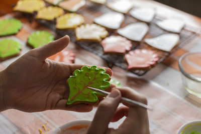 Close-up of hand holding leaf on table