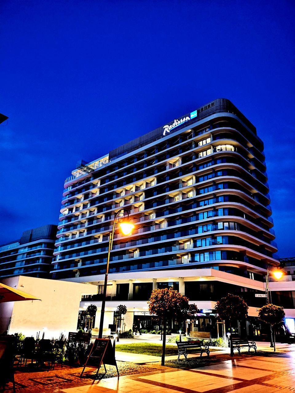 LOW ANGLE VIEW OF ILLUMINATED BUILDING AGAINST BLUE SKY AT NIGHT