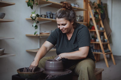 Middle-aged woman working on a potter's wheel