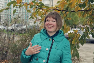 Portrait of smiling young woman standing in park