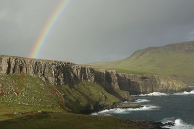 Scenic view of rainbow over sea against sky