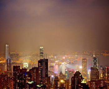 Illuminated buildings in city against sky at night