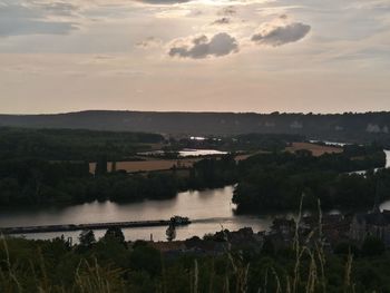 Scenic view of river against sky at sunset