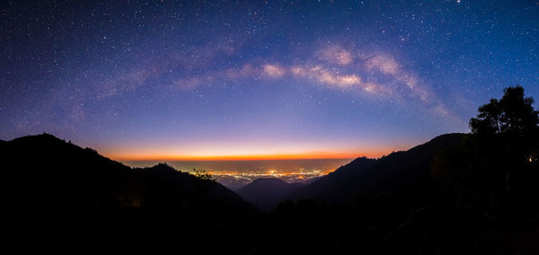 Silhouette mountains against sky at night