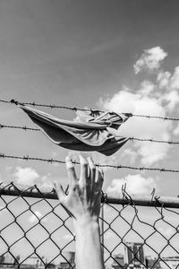 Close-up of hand against sky