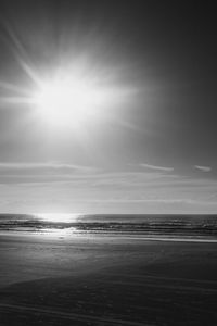 Scenic view of sea against bright sun