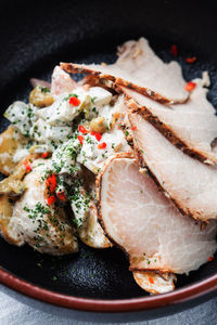 Slices of yummy ham arranged on vegetable salad with cream sauce on plate in cafeteria