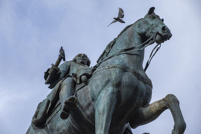 Low angle view of angel statue against sky