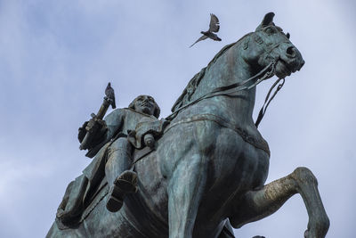 Pigeons on the statue of carlos iii in the puerta del sol square, madrid.