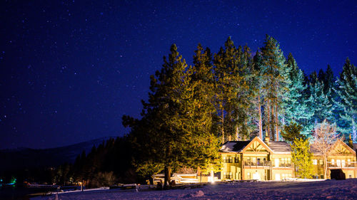 Illuminated houses against sky at night