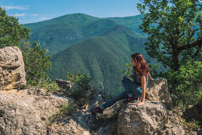 Man sitting on rock looking at mountains