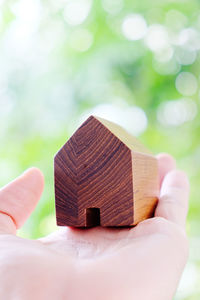 Cropped hand of person holding model house