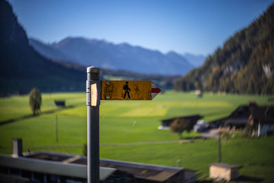 Information sign on field against sky