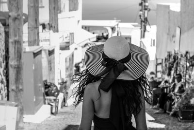 Rear view of woman standing by hat in city