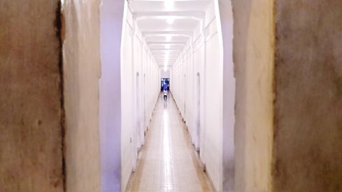 Panoramic view of man walking in corridor of building