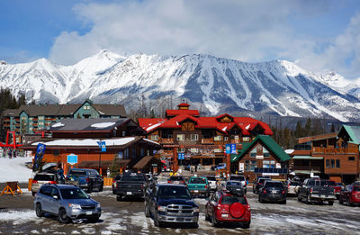 Cars on snow covered mountains against sky