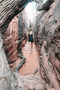 Young female hiking through narrow canyon in utah