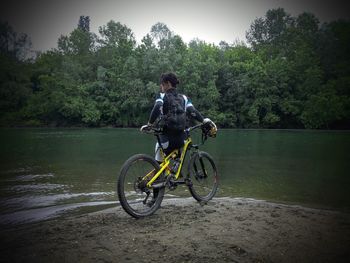 Man with bicycle on riverbank