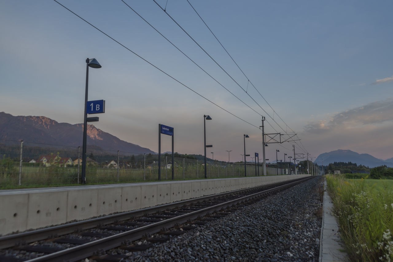 RAILROAD TRACKS AGAINST SKY DURING SUNSET