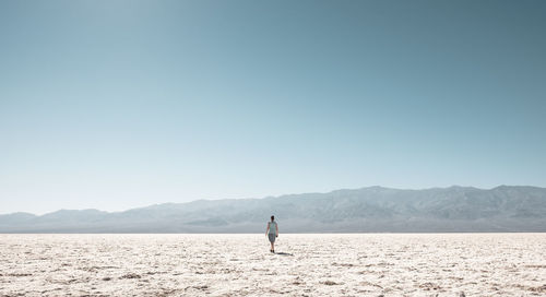 Man on mountain against clear sky