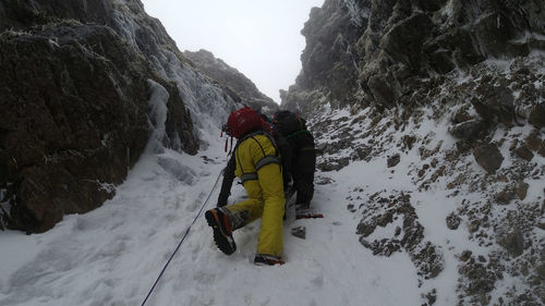 Rear view of people on snow covered mountain