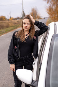 Beautiful woman standing by car outdoors