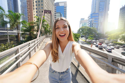 Beautiful smiling girl takes self portrait in moema financial district of sao paulo, brazil.