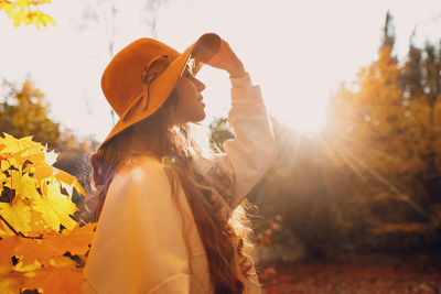 Rear view of woman standing against yellow flower