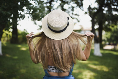 Rear view of woman wearing hat standing outdoors