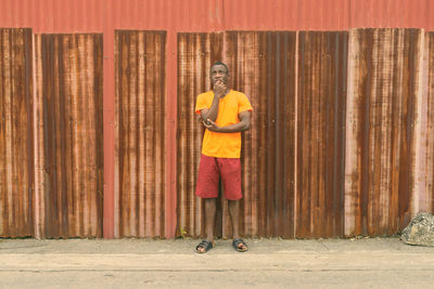 Portrait of man standing against wall