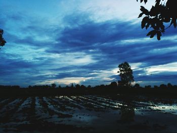 Silhouette landscape against cloudy sky