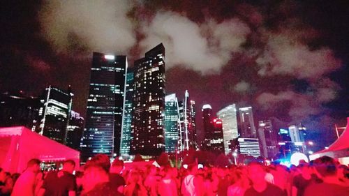 Crowd in city against sky at night