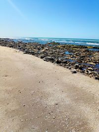 Scenic view of beach against clear blue sky