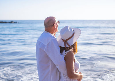 Rear view of woman standing at beach