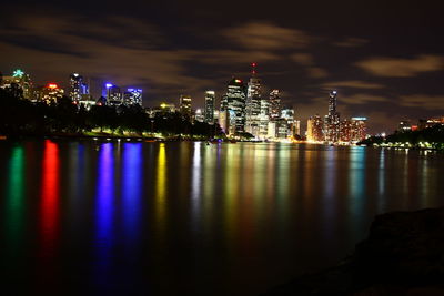 Reflection of illuminated city lights on river at night