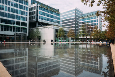 Reflection of buildings in swimming pool against sky