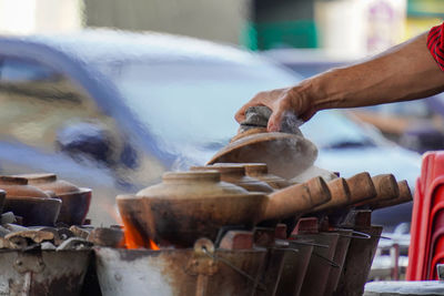 Man checking if the claypot chicken rice is done