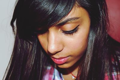 Close-up of beautiful young woman with brown hair looking down