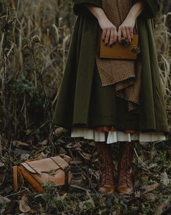 Low section of woman holding an old book