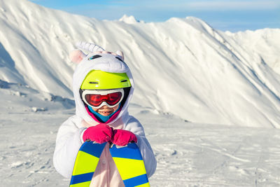 Portrait of child on snowcapped mountains during winter