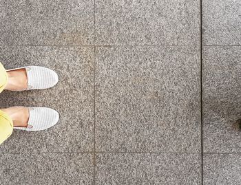 Low section of woman standing on tiled floor