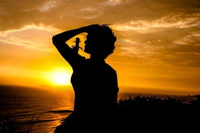 Silhouette of man standing against sky during sunset